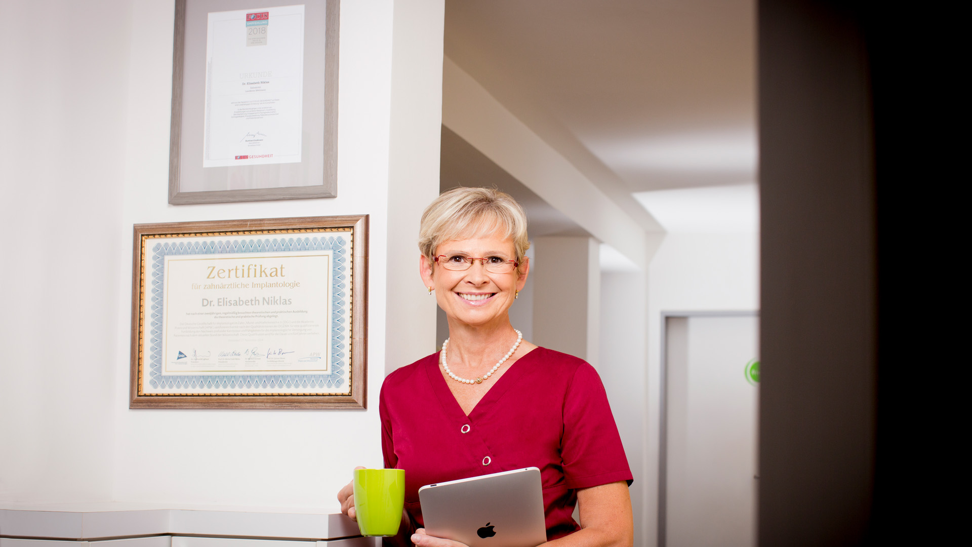 Zahnärztin Dr. Niklas: Die Zahnärztin steht vor ihrer Urkunde vom Zertifikat.